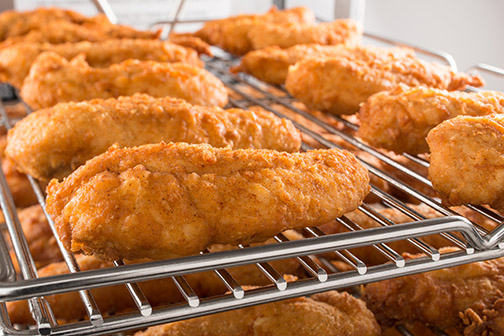 Golden Juicy Pressure Fried Chicken Tenders on a Rack