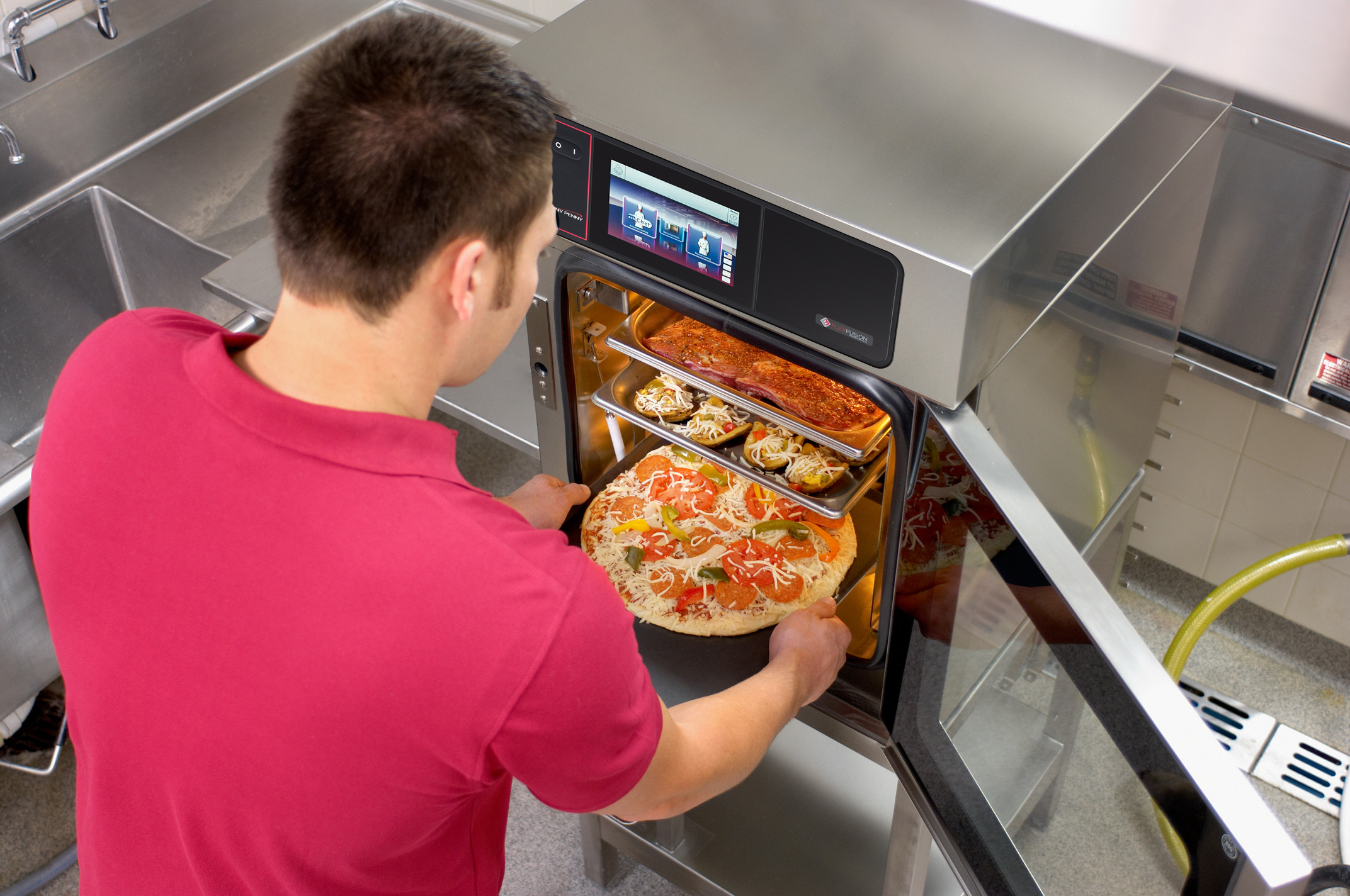 cook loading a round pizza into a space saver combi oven.